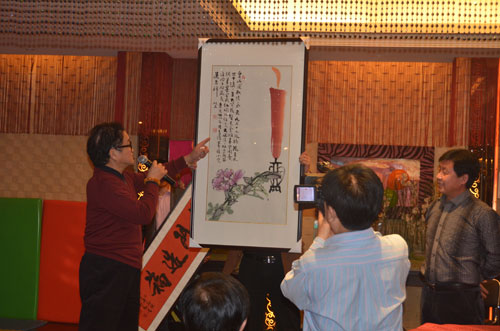 画家曹明冉(左一)赠画与艺术天成杂志社总编辑杨摩根娱乐(右一)